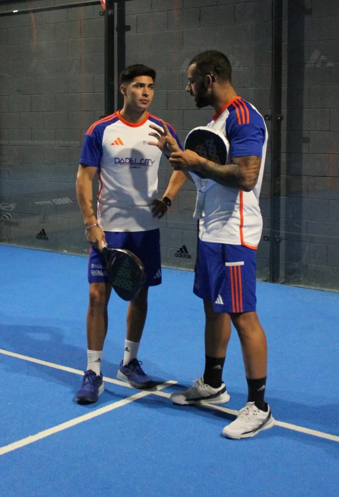 Due maestri di PadelCity parlano in campo, con le racchette in mano e la maglia del club